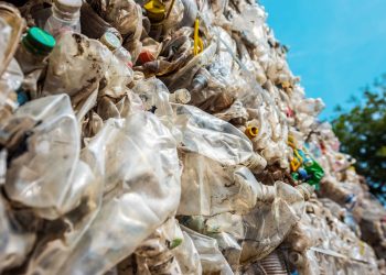 Close view of a cube of compressed plastic garbage near the waste recycling factory in open air