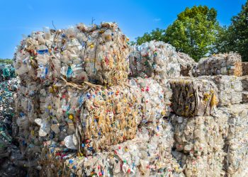 Multiple cubes of compressed plastic garbage near the waste recycling factory in open air